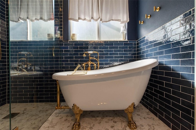 690 Cascading Creek Ln, Winter Garden, FL 34787 - bathroom with a freestanding tub, tile walls, wainscoting, and a tile shower