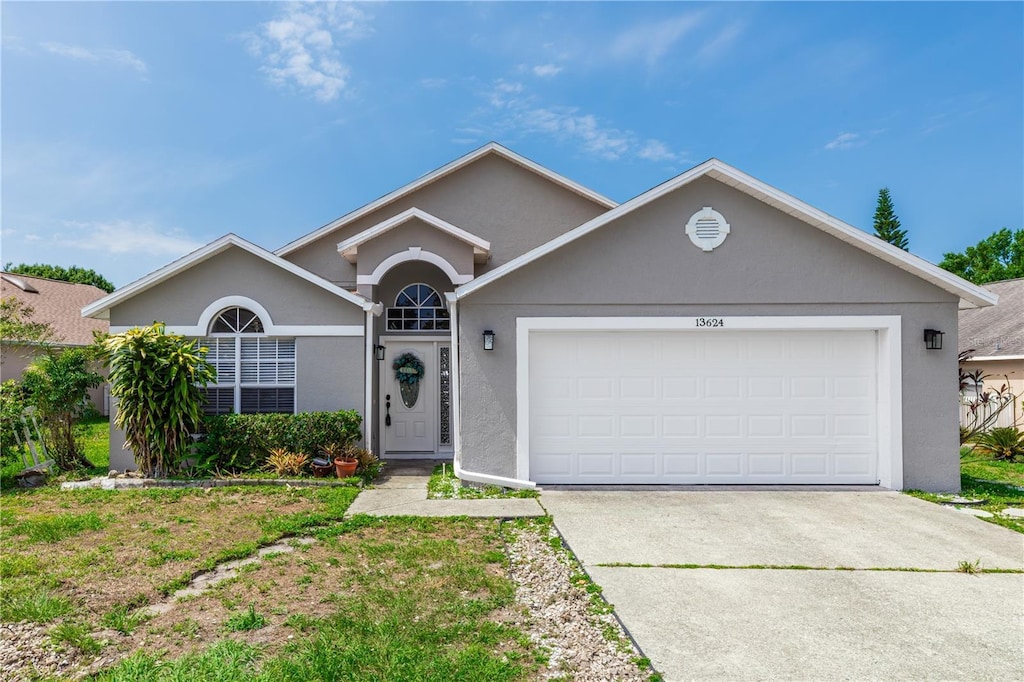 13624 Springtide Ct, Orlando, FL 32826 - single story home featuring a garage, driveway, and stucco siding