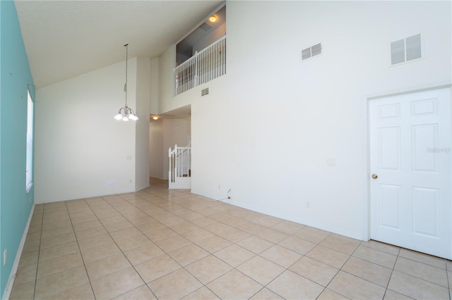 2434 Temple Grove Ln, Kissimmee, FL 34741 - spare room featuring light tile patterned floors, visible vents, high vaulted ceiling, and an inviting chandelier