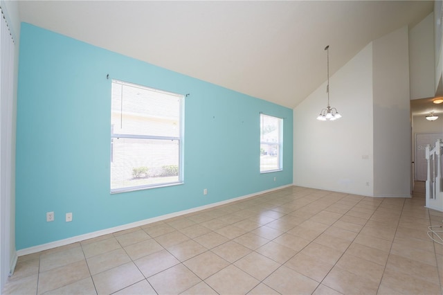 2434 Temple Grove Ln, Kissimmee, FL 34741 - spare room with baseboards, high vaulted ceiling, a notable chandelier, and light tile patterned flooring
