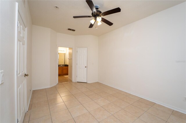 2434 Temple Grove Ln, Kissimmee, FL 34741 - unfurnished bedroom with baseboards, visible vents, a ceiling fan, connected bathroom, and light tile patterned floors