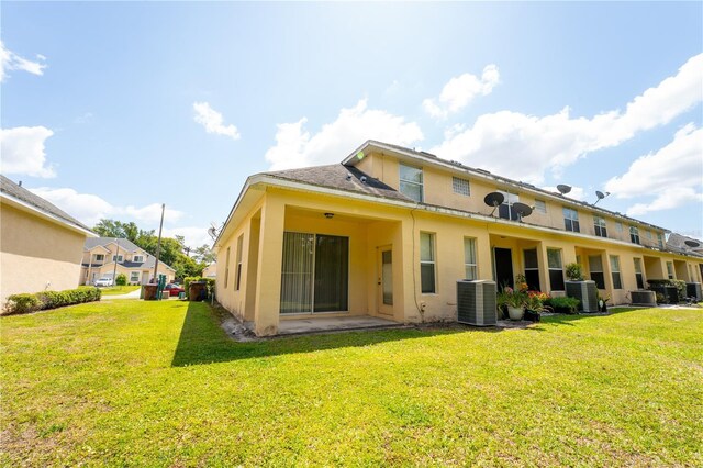 2434 Temple Grove Ln, Kissimmee, FL 34741 - rear view of property with central AC, a yard, and stucco siding