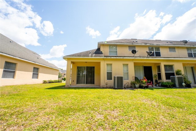 2434 Temple Grove Ln, Kissimmee, FL 34741 - back of house featuring stucco siding, a yard, and central AC unit