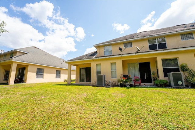 2434 Temple Grove Ln, Kissimmee, FL 34741 - rear view of house featuring a lawn, central AC, and stucco siding