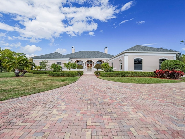 2266 12th St, Vero Beach, FL 32960 - view of front of house featuring a front lawn, a chimney, decorative driveway, and stucco siding