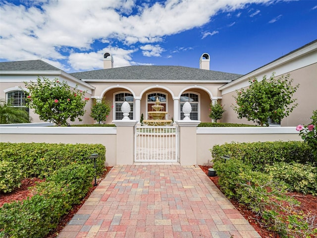 2266 12th St, Vero Beach, FL 32960 - view of front of house with a gate, stucco siding, a chimney, and a fenced front yard