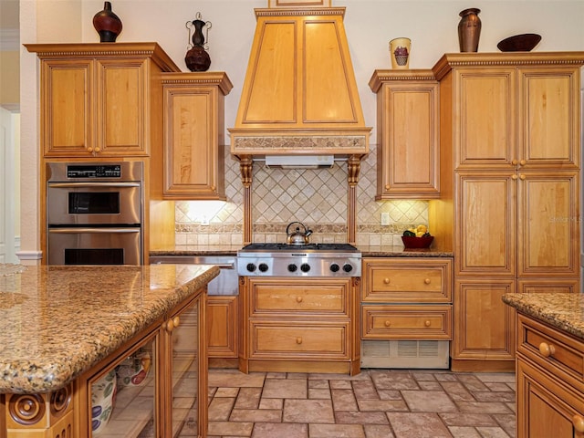 2266 12th St, Vero Beach, FL 32960 - kitchen with stone counters, custom exhaust hood, backsplash, brown cabinetry, and appliances with stainless steel finishes