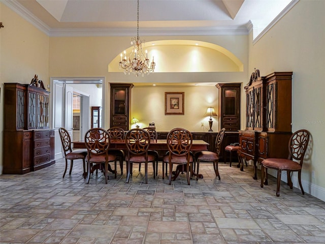 2266 12th St, Vero Beach, FL 32960 - dining area with stone tile floors, an inviting chandelier, crown molding, baseboards, and high vaulted ceiling