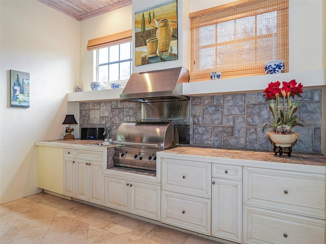 2266 12th St, Vero Beach, FL 32960 - kitchen with tile countertops, ornamental molding, a sink, wall chimney exhaust hood, and decorative backsplash