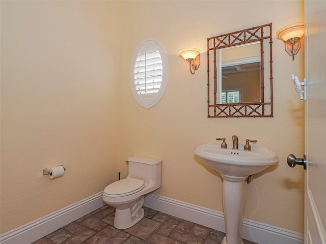 2266 12th St, Vero Beach, FL 32960 - bathroom featuring stone finish flooring, toilet, and baseboards