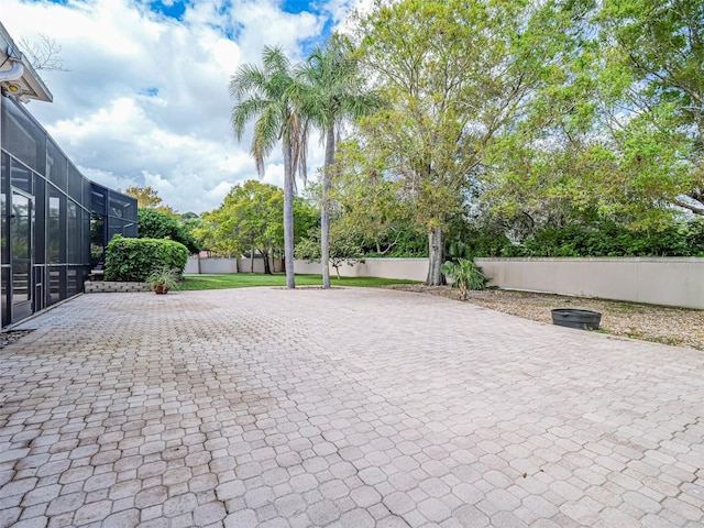 2266 12th St, Vero Beach, FL 32960 - view of patio / terrace with fence, decorative driveway, and glass enclosure