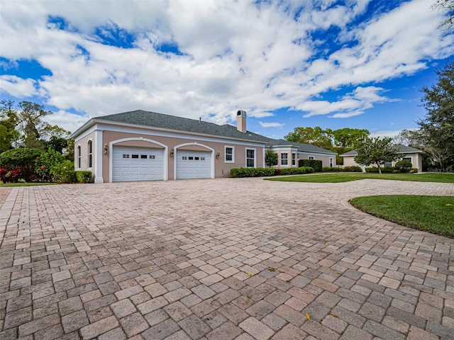 2266 12th St, Vero Beach, FL 32960 - ranch-style house with a chimney, curved driveway, a front yard, a garage, and stucco siding