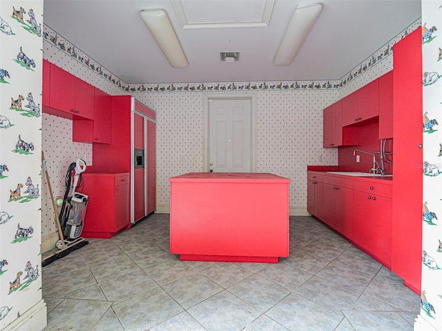 2266 12th St, Vero Beach, FL 32960 - kitchen with wallpapered walls, red cabinets, visible vents, light tile patterned floors, and a sink
