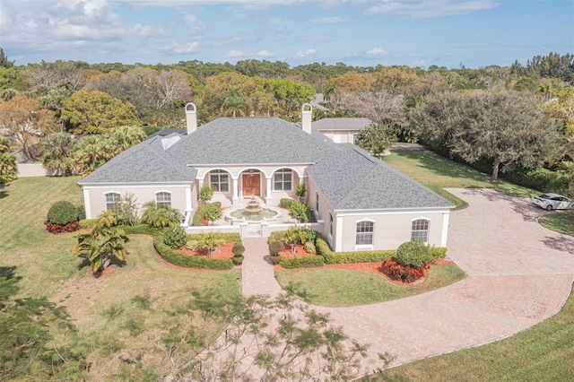 2266 12th St, Vero Beach, FL 32960 - view of front of house featuring roof with shingles, driveway, a chimney, a front yard, and stucco siding
