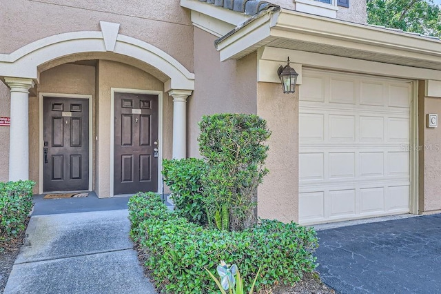 14238 Fredricksburg Dr Unit 310, Orlando, FL 32837 - doorway to property featuring stucco siding and a garage