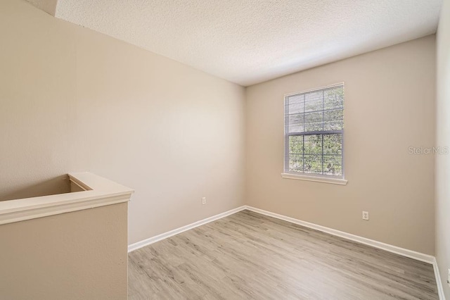 14238 Fredricksburg Dr Unit 310, Orlando, FL 32837 - unfurnished room with a textured ceiling, baseboards, and light wood-type flooring