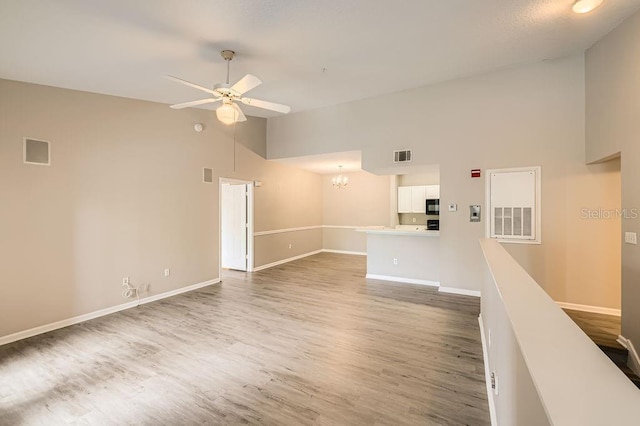 14238 Fredricksburg Dr Unit 310, Orlando, FL 32837 - unfurnished room with baseboards, visible vents, wood finished floors, and ceiling fan with notable chandelier