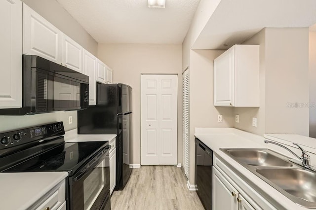 14238 Fredricksburg Dr Unit 310, Orlando, FL 32837 - kitchen featuring white cabinetry, a sink, light countertops, black appliances, and light wood finished floors