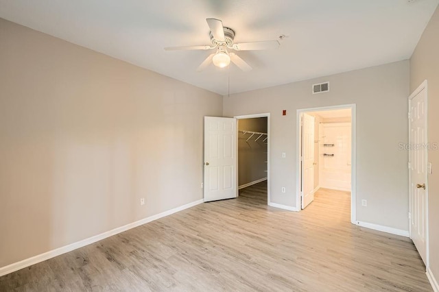 14238 Fredricksburg Dr Unit 310, Orlando, FL 32837 - unfurnished bedroom featuring visible vents, a spacious closet, light wood-style flooring, and baseboards