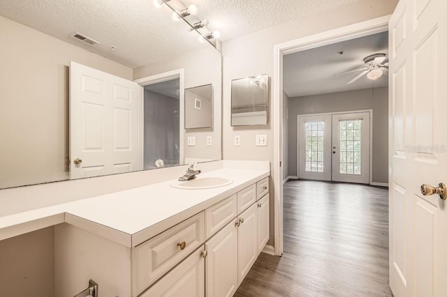 14238 Fredricksburg Dr Unit 310, Orlando, FL 32837 - bathroom with wood finished floors, vanity, a ceiling fan, a textured ceiling, and french doors