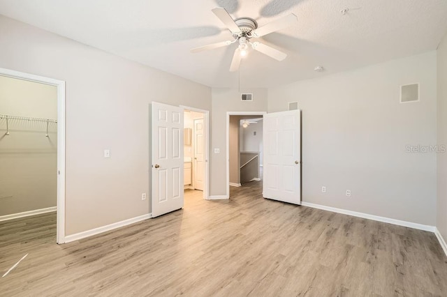 14238 Fredricksburg Dr Unit 310, Orlando, FL 32837 - unfurnished bedroom featuring a closet, a walk in closet, baseboards, and light wood-style floors