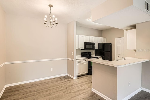 14238 Fredricksburg Dr Unit 310, Orlando, FL 32837 - kitchen with light wood finished floors, a chandelier, black appliances, white cabinetry, and baseboards