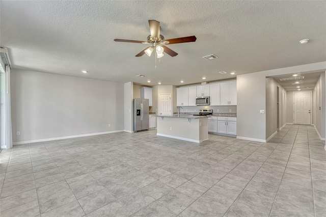 439 Sarah Nicole Way, New Smyrna Beach, FL 32168 - kitchen with recessed lighting, a textured ceiling, open floor plan, and stainless steel appliances