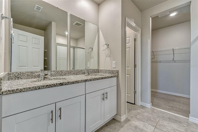 439 Sarah Nicole Way, New Smyrna Beach, FL 32168 - bathroom featuring a sink, double vanity, visible vents, a shower stall, and a walk in closet