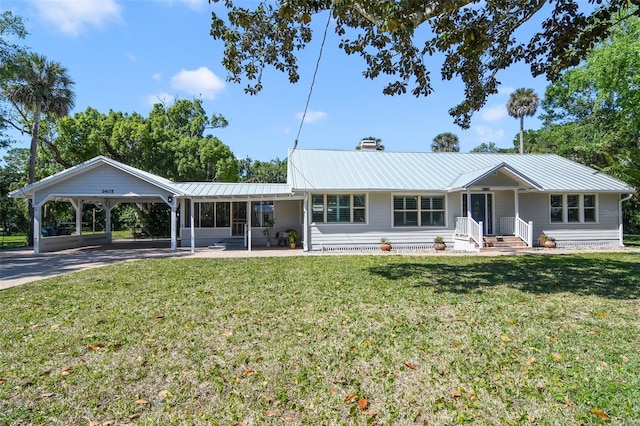 ranch-style house featuring a chimney, driveway, a carport, a front yard, and metal roof