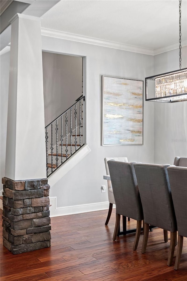 dining area featuring baseboards, wood finished floors, stairway, and crown molding