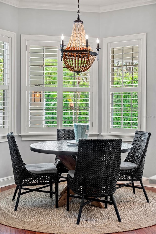 dining space featuring plenty of natural light, ornamental molding, baseboards, and a notable chandelier