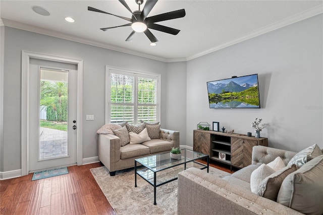 living area featuring baseboards, recessed lighting, a ceiling fan, wood finished floors, and ornamental molding