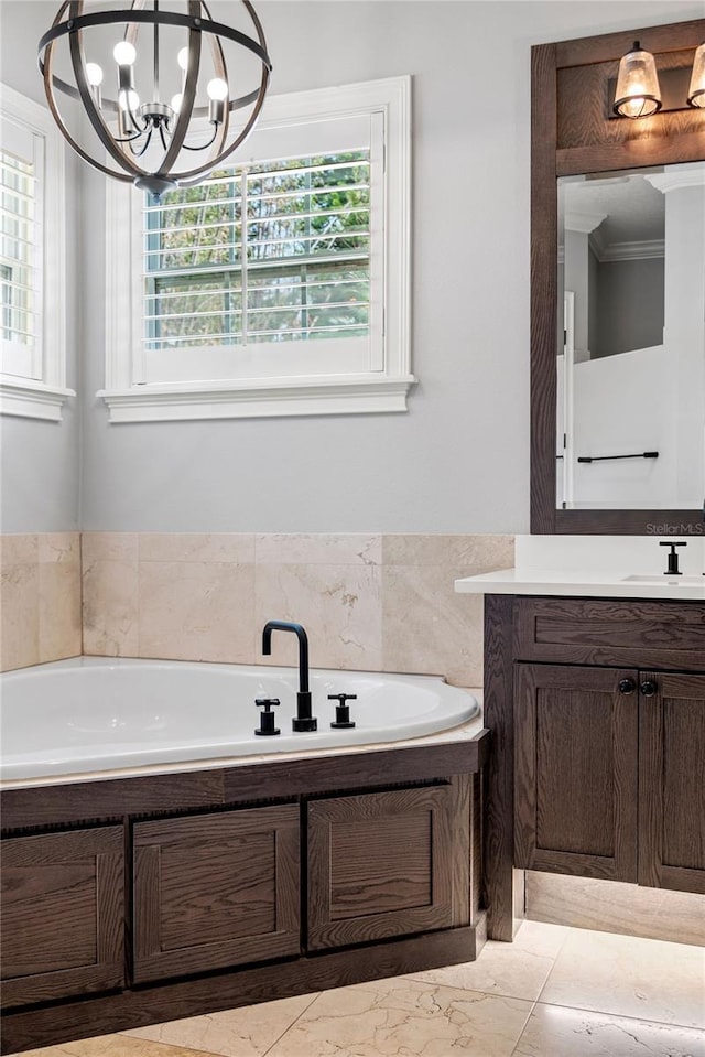 bathroom with a bath, vanity, a chandelier, and ornamental molding