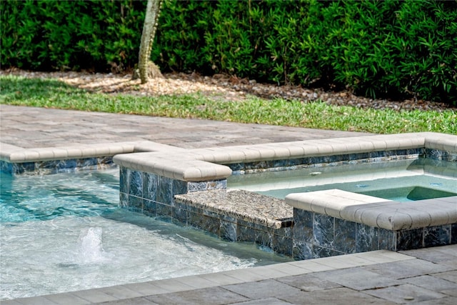 view of pool with a pool with connected hot tub