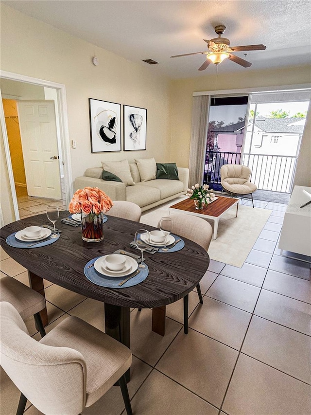 living room with a ceiling fan, light tile patterned flooring, and visible vents