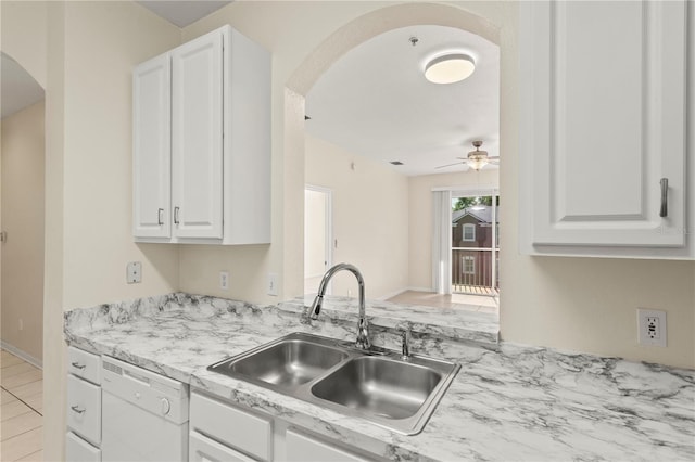 kitchen featuring white cabinets, arched walkways, a sink, white dishwasher, and ceiling fan