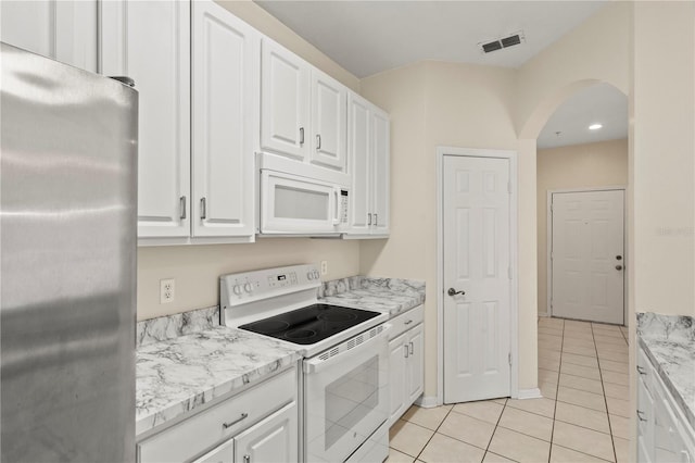 kitchen featuring light tile patterned flooring, white appliances, arched walkways, white cabinets, and visible vents