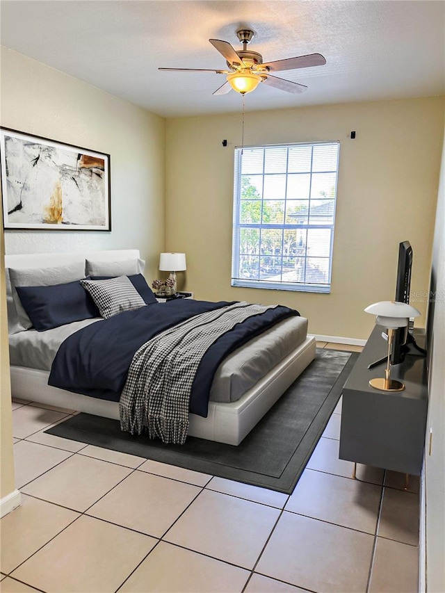 tiled bedroom with a ceiling fan