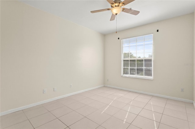 unfurnished room with light tile patterned floors, baseboards, and ceiling fan