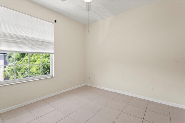 empty room featuring light tile patterned floors, baseboards, and ceiling fan