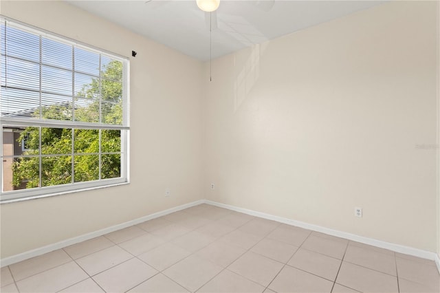 unfurnished room featuring baseboards, a ceiling fan, and light tile patterned floors