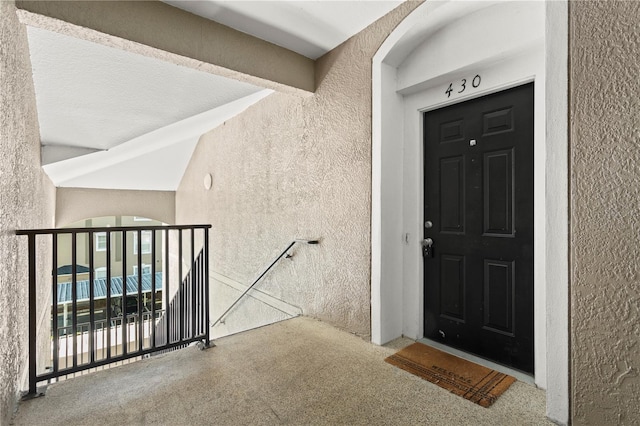 view of exterior entry featuring a balcony