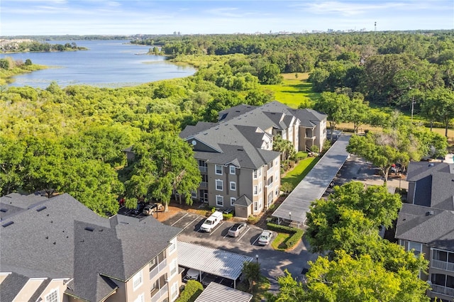 bird's eye view featuring a wooded view, a residential view, and a water view