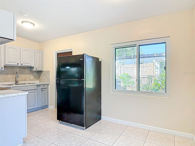 4514 Southmore Dr, Orlando, FL 32812 - kitchen with light tile patterned floors, a sink, light countertops, freestanding refrigerator, and baseboards