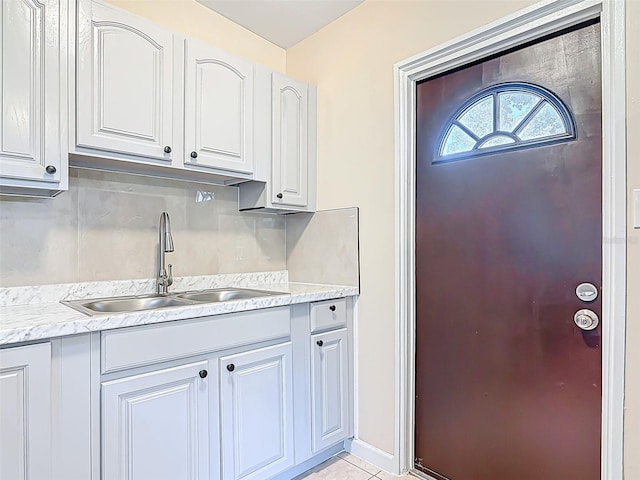 4514 Southmore Dr, Orlando, FL 32812 - kitchen with light tile patterned floors, white cabinetry, a sink, light countertops, and baseboards