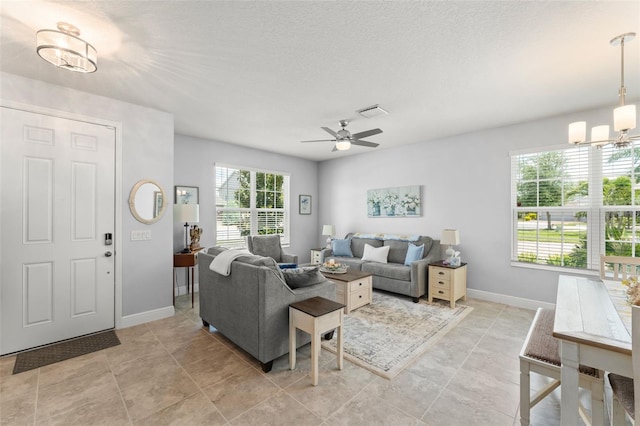 living area with visible vents, baseboards, and ceiling fan