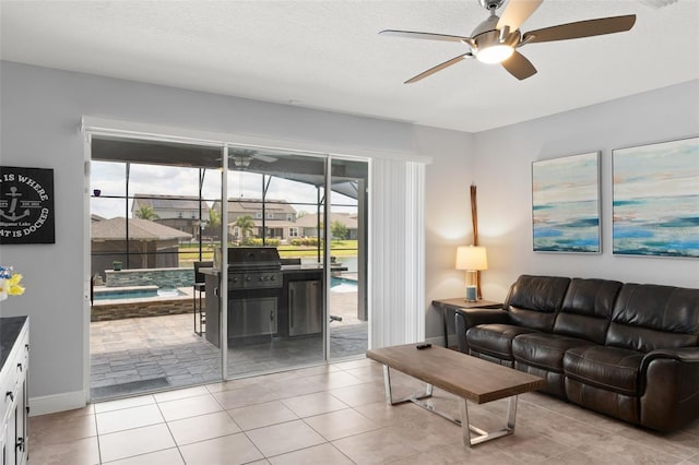 living area featuring baseboards, ceiling fan, and light tile patterned flooring