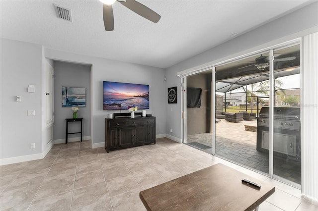 living room with baseboards, a ceiling fan, visible vents, and a sunroom