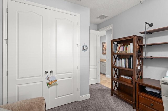 interior space with baseboards, visible vents, carpet floors, and a textured ceiling