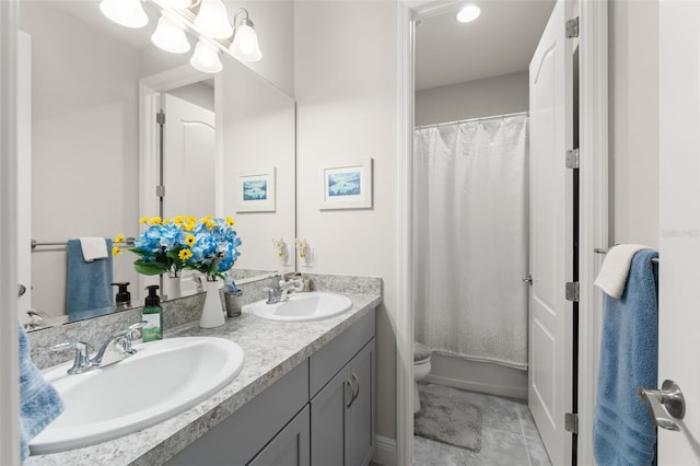 bathroom with curtained shower, a sink, double vanity, and toilet